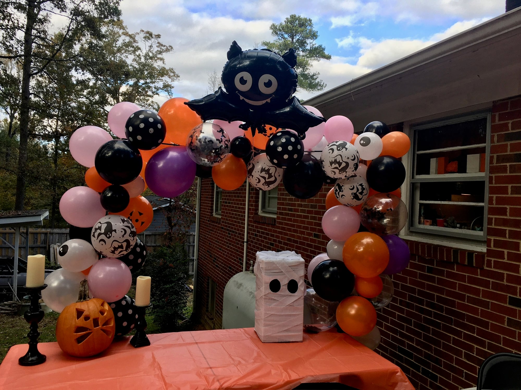 Full Halloween balloon arch in pink, orange, purple, and black