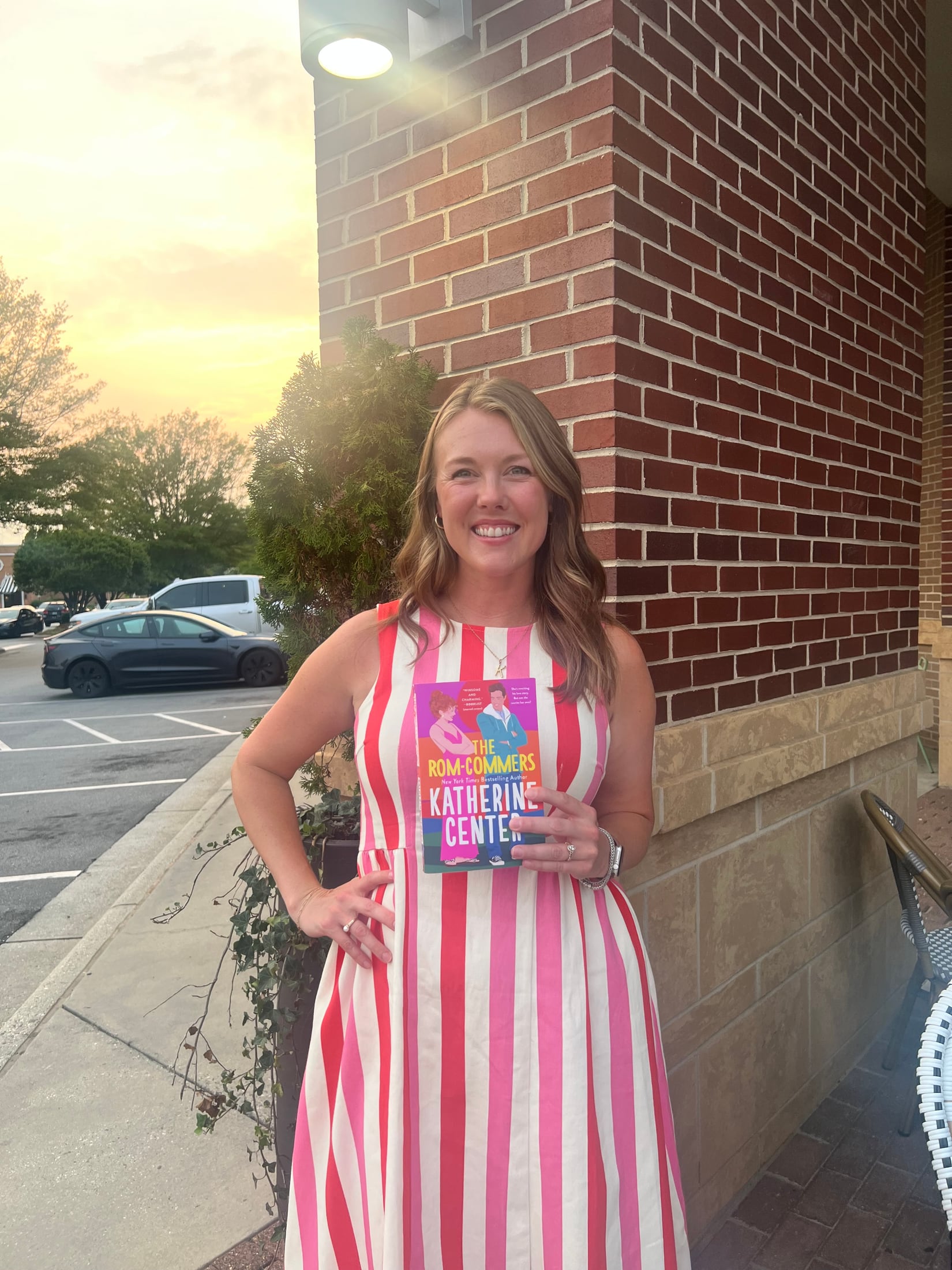 Pink Porch book club host holding the featured book