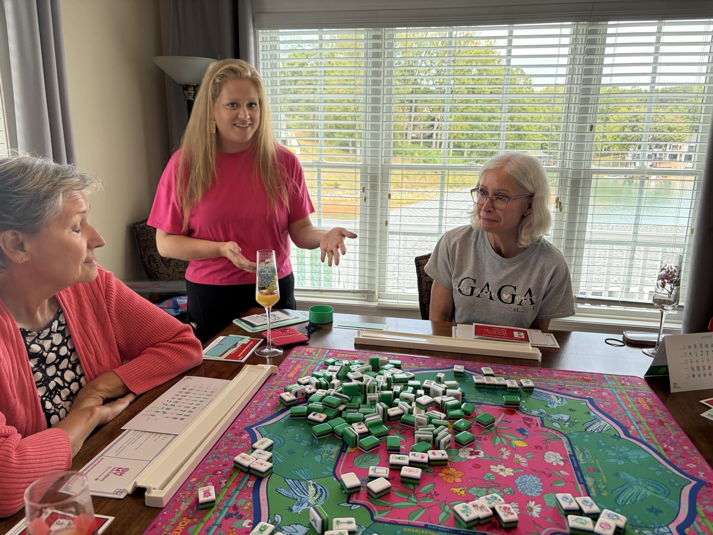 A Pink Porch host welcoming women gathered around a Mahjong table