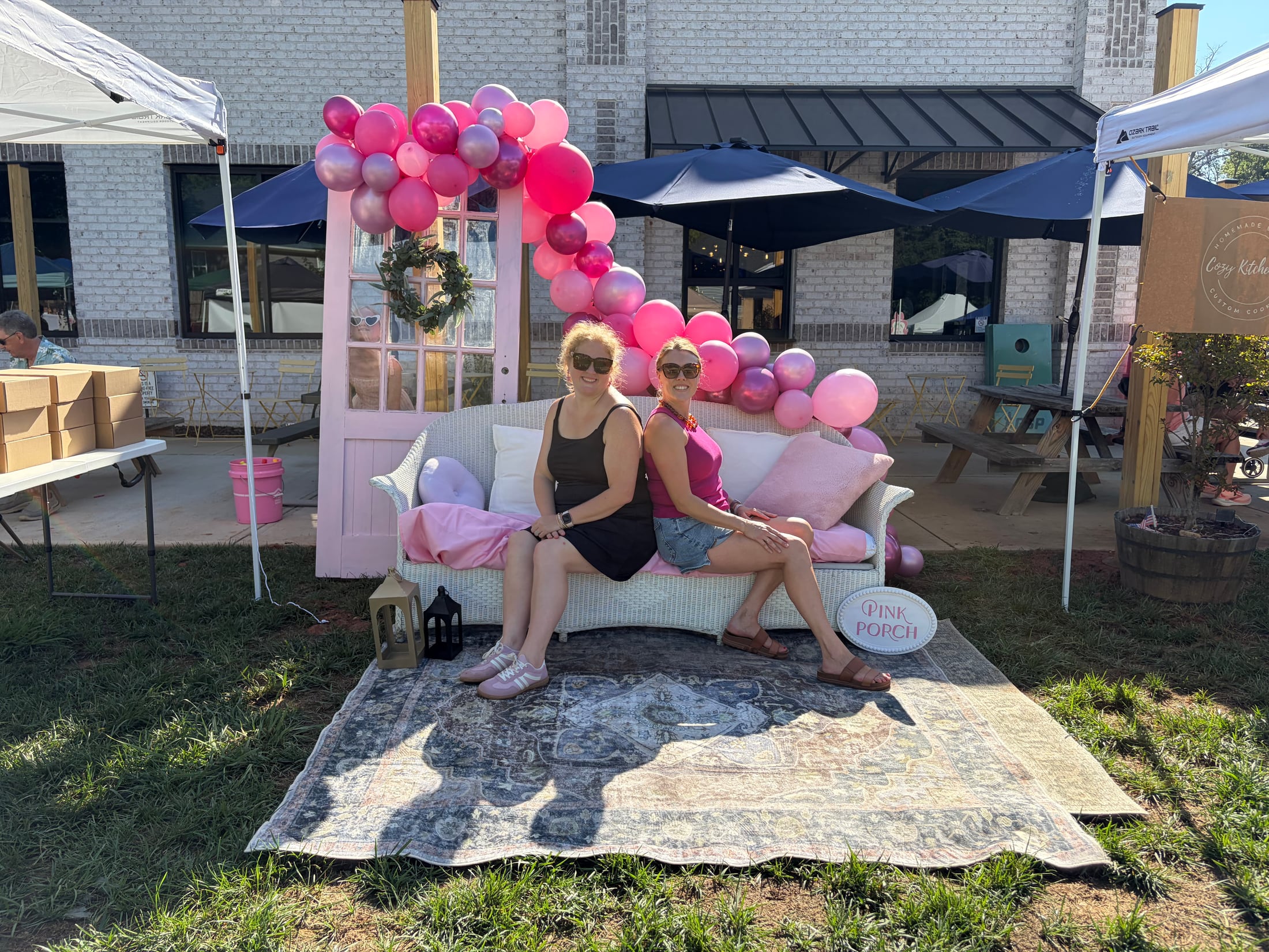 Sara and Katie at a colorful Pink Porch market setup